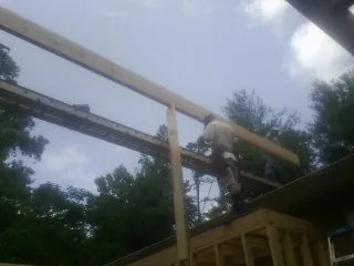 Carpenter setting a ridge beam over a new addition frame — Ice Dam Removal by Roofing Brothers in Canistota