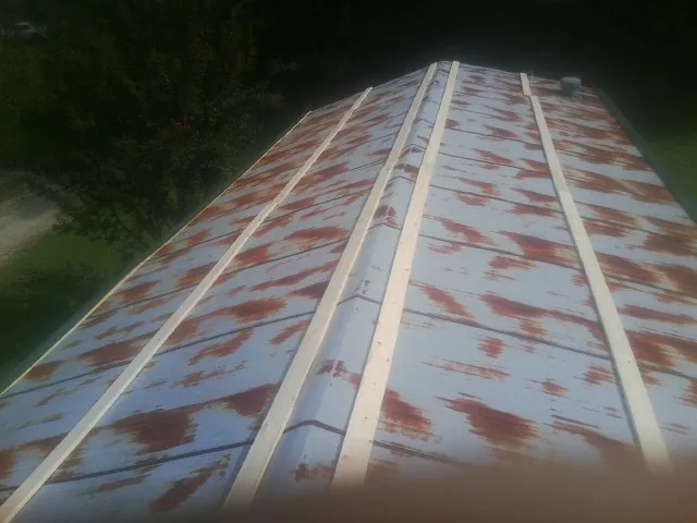 Rusted metal roof panels with new wood purlins before replacement — Storm Damage Roof Repair in Canistota by Roofing Brothers