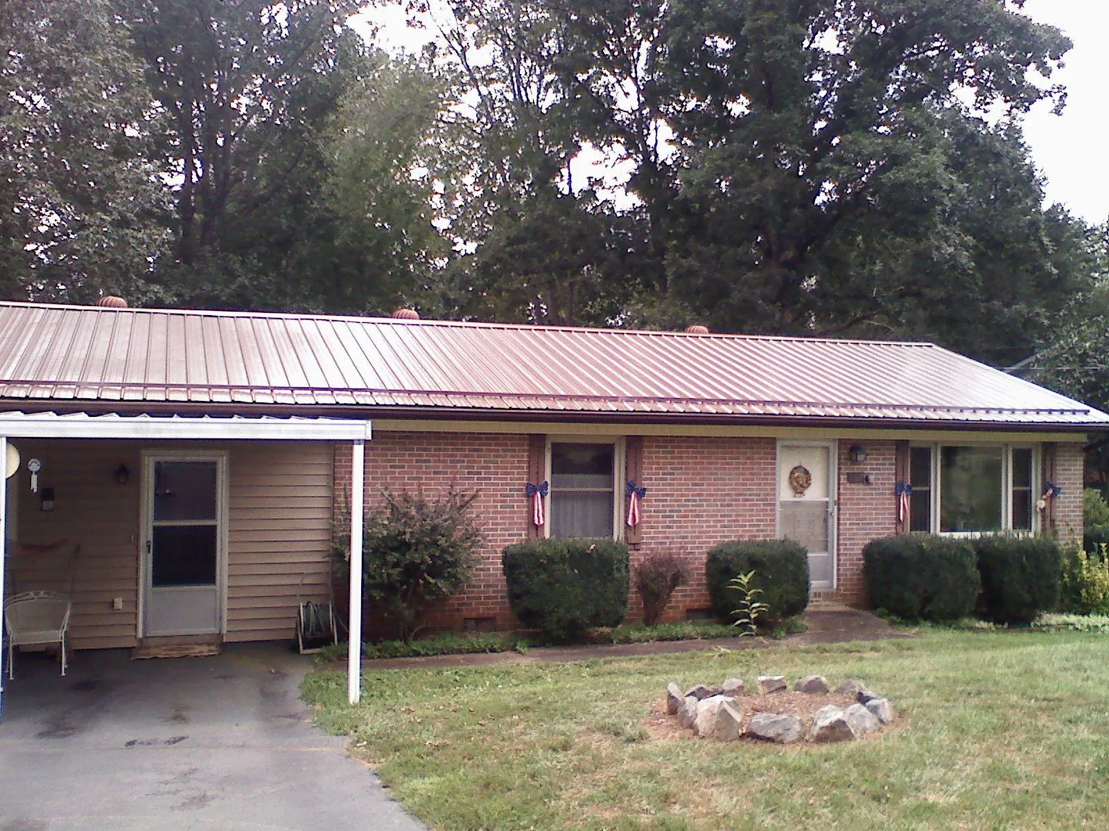 Bronze metal roof and carport on a brick ranch home — Roof Repair work by our crew in Canistota